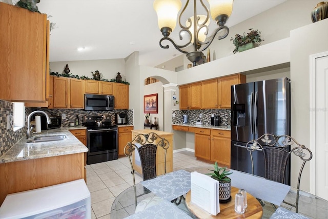 kitchen with appliances with stainless steel finishes, sink, pendant lighting, an inviting chandelier, and light tile patterned flooring