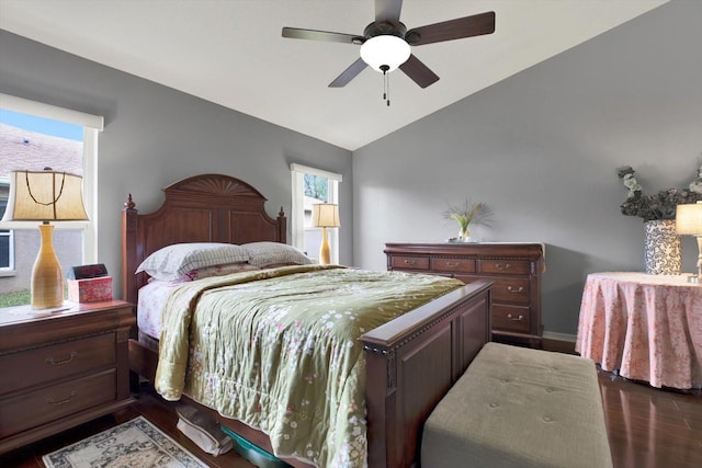 bedroom featuring dark hardwood / wood-style flooring, vaulted ceiling, and ceiling fan