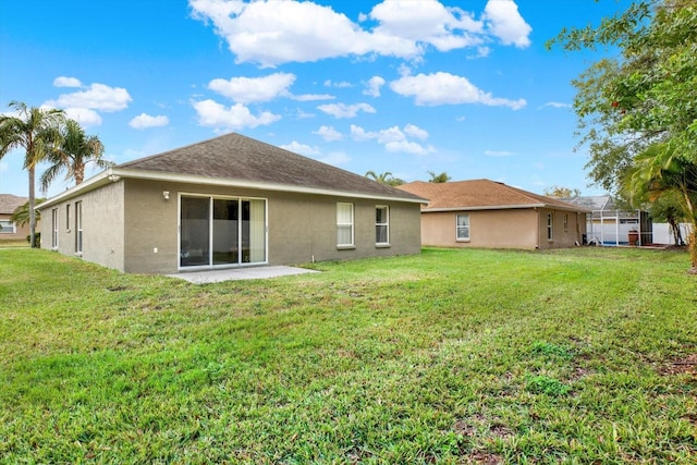 rear view of house featuring a yard and a patio