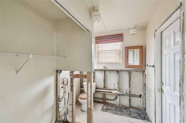 bathroom featuring toilet and concrete flooring