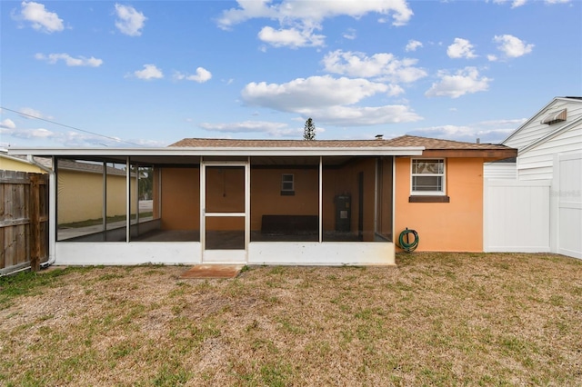 rear view of property with a sunroom and a yard