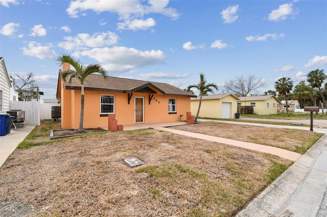 single story home featuring a garage and cooling unit