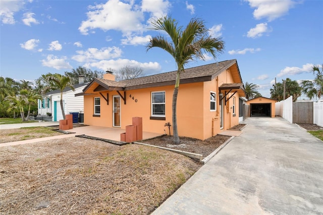 440 77th Ave, St Pete Beach, FL 33706 - view of front of house featuring stucco siding, concrete driveway, a detached garage, and a chimney