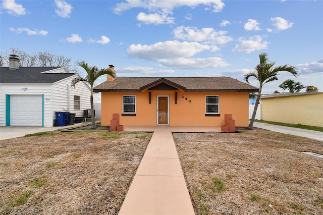 440 77th Ave, St Pete Beach, FL 33706 - view of front of home featuring stucco siding and an attached garage