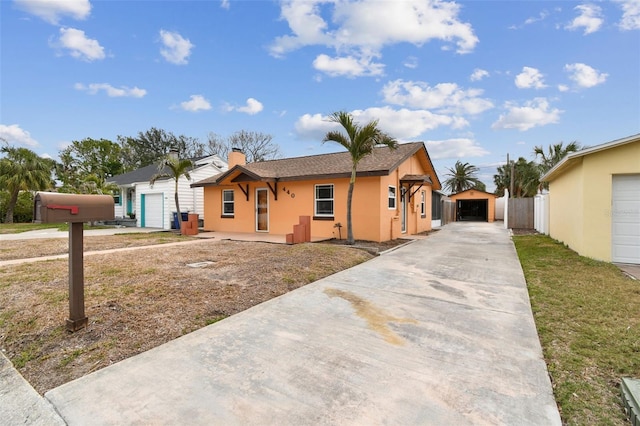 440 77th Ave, St Pete Beach, FL 33706 - ranch-style house featuring a chimney, driveway, a detached garage, and stucco siding
