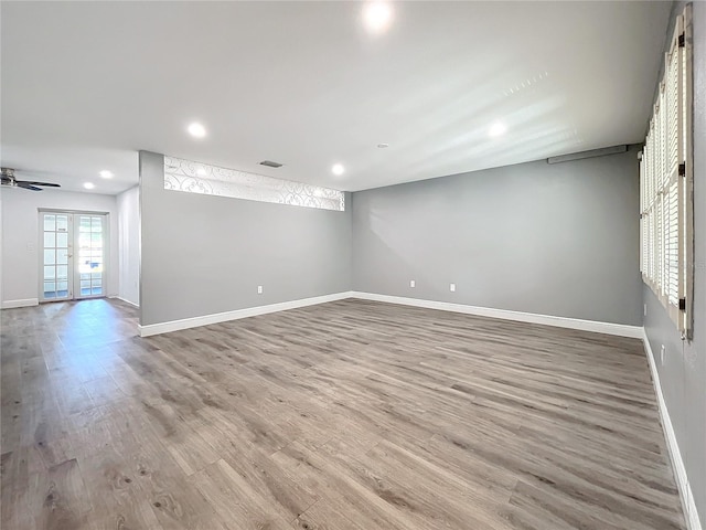 empty room with wood-type flooring, french doors, and ceiling fan