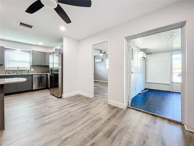 kitchen with gray cabinetry, ceiling fan, light hardwood / wood-style floors, and stainless steel appliances