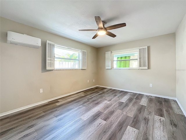 spare room with hardwood / wood-style flooring, ceiling fan, and a wall mounted AC