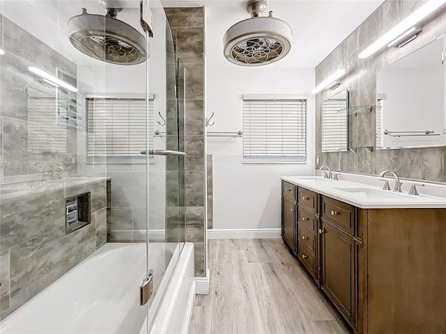 bathroom featuring hardwood / wood-style flooring, vanity, and combined bath / shower with glass door