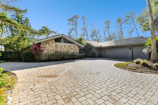 5474 Kemkerry Rd, Wesley Chapel, FL 33543 - view of home's exterior with a garage, stone siding, and driveway