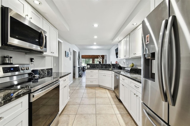 5474 Kemkerry Rd, Wesley Chapel, FL 33543 - kitchen featuring appliances with stainless steel finishes, a peninsula, recessed lighting, white cabinets, and light tile patterned flooring