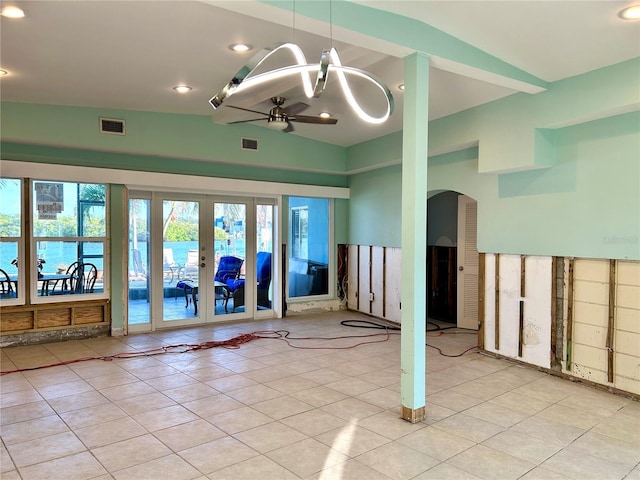 tiled empty room featuring ceiling fan, french doors, and lofted ceiling