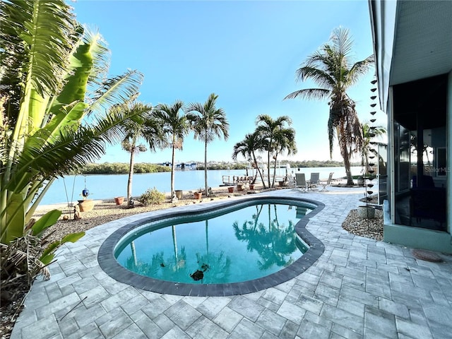 view of pool with a water view and a patio area