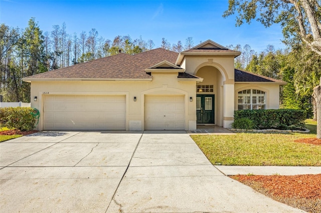 view of front of home featuring a garage, a front yard, and french doors