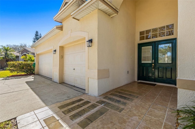 doorway to property with a garage and french doors