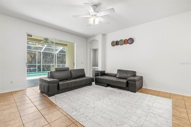 tiled living room with ceiling fan and a textured ceiling