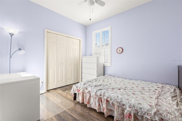 bedroom with ceiling fan, wood-type flooring, fridge, and a closet