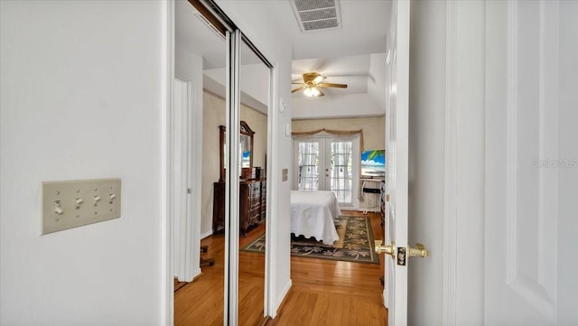 corridor featuring wood-type flooring and french doors