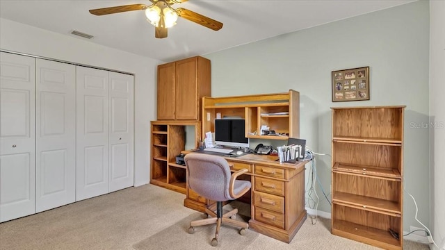 carpeted home office featuring ceiling fan