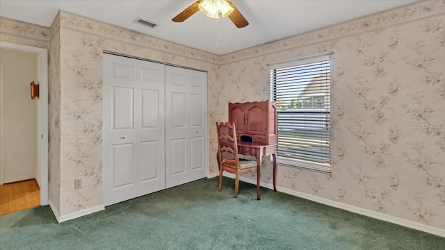 interior space featuring dark carpet and ceiling fan