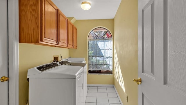 laundry room featuring separate washer and dryer, light tile patterned floors, sink, and cabinets