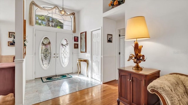 entryway featuring a high ceiling, light hardwood / wood-style flooring, and french doors