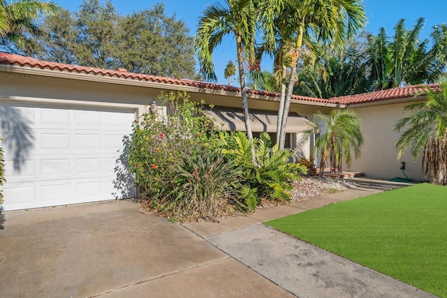 mediterranean / spanish-style house featuring a garage and a front lawn