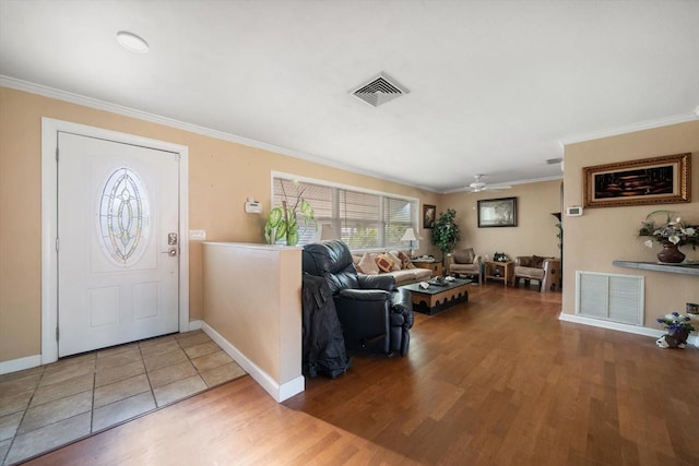 entryway with ceiling fan, crown molding, and wood-type flooring