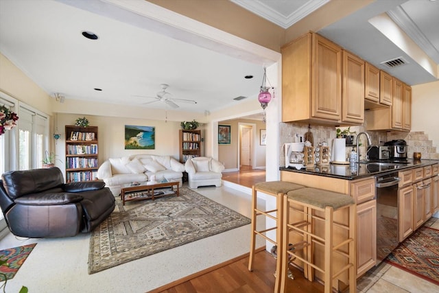 kitchen with sink, a kitchen bar, ceiling fan, light hardwood / wood-style flooring, and decorative backsplash