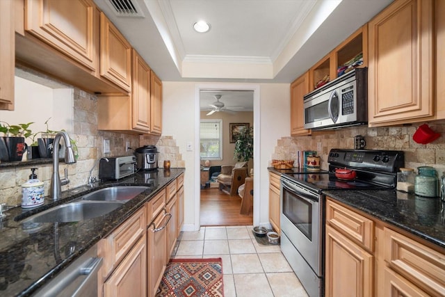 kitchen featuring sink, light tile patterned floors, a tray ceiling, crown molding, and appliances with stainless steel finishes