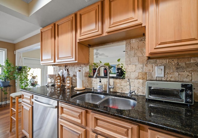 kitchen with dark stone countertops, crown molding, sink, stainless steel dishwasher, and tasteful backsplash