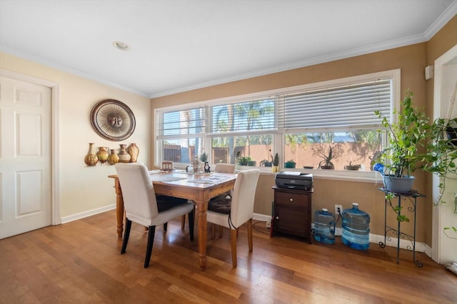 dining area featuring ornamental molding and light hardwood / wood-style flooring