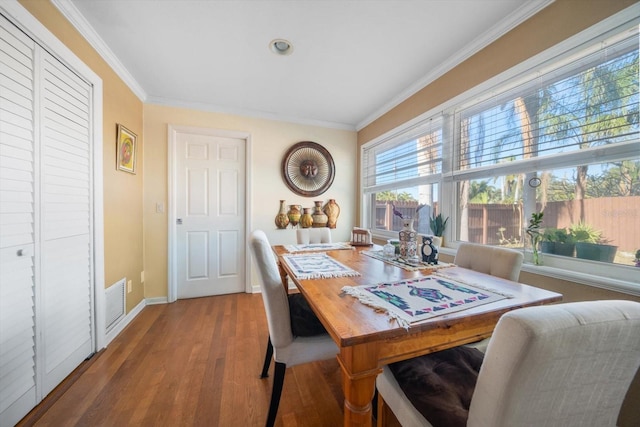 dining room with ornamental molding and hardwood / wood-style flooring