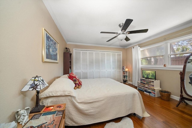 bedroom with ceiling fan, ornamental molding, a closet, and wood-type flooring