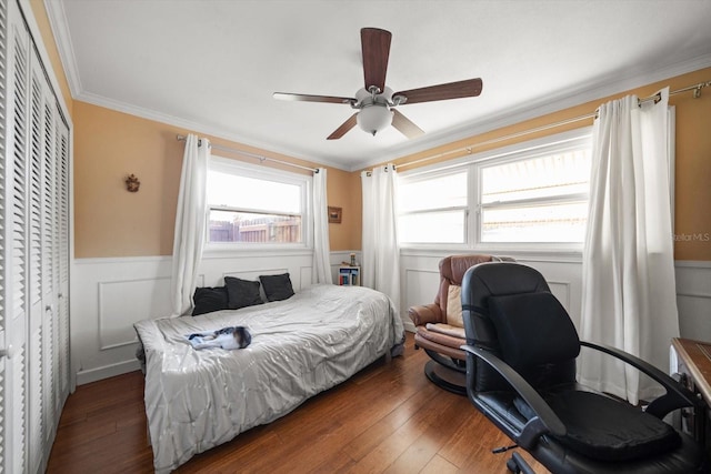 bedroom featuring ceiling fan, dark hardwood / wood-style flooring, ornamental molding, and a closet