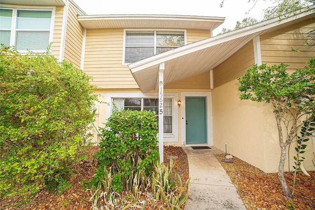 entrance to property featuring stucco siding