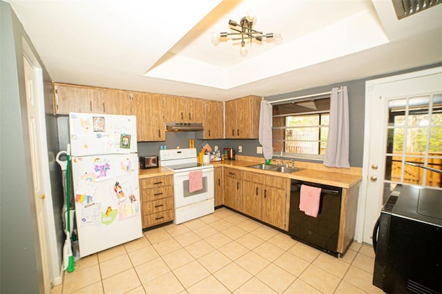 kitchen with white appliances, a sink, light countertops, under cabinet range hood, and a raised ceiling