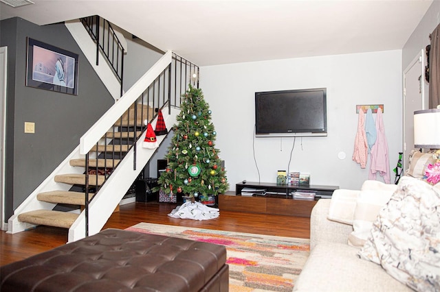 living area featuring stairs, wood finished floors, and visible vents