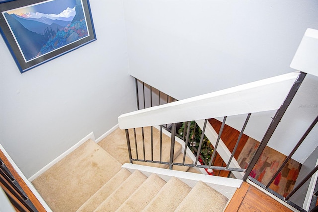 stairs featuring baseboards and carpet flooring