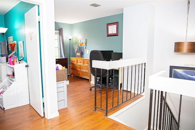 interior space with wood finished floors, an upstairs landing, and visible vents