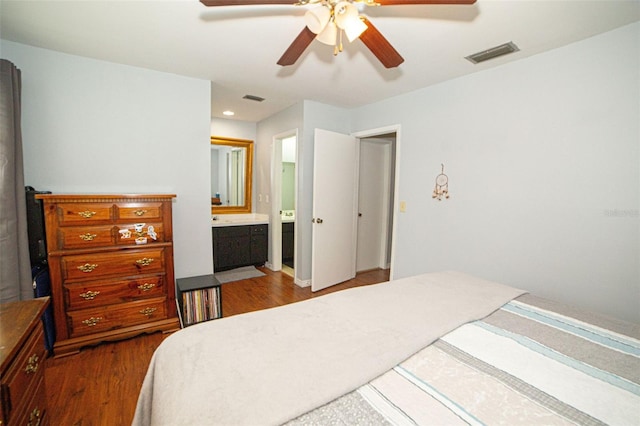 bedroom with ceiling fan, visible vents, dark wood finished floors, and ensuite bathroom