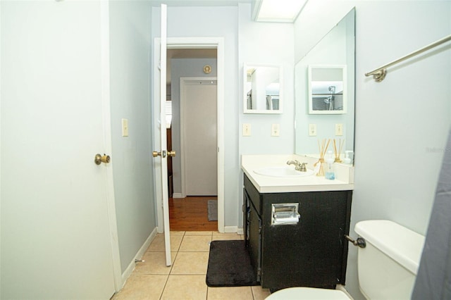 bathroom featuring tile patterned flooring, toilet, vanity, and baseboards