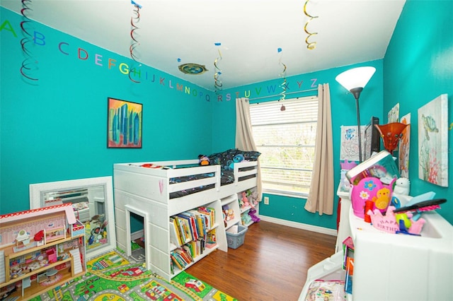 bedroom with baseboards and wood finished floors