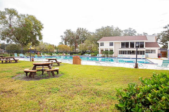 pool with a patio area, a lawn, and fence