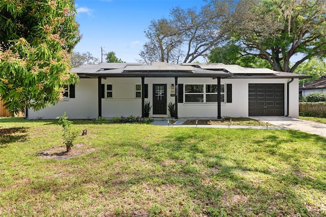 ranch-style house with solar panels, covered porch, a front yard, and a garage