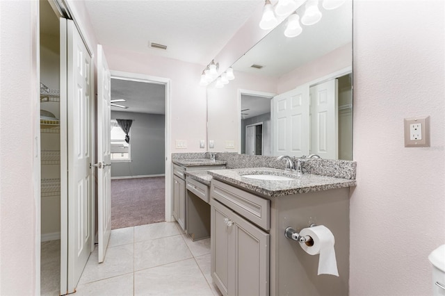 bathroom with tile patterned flooring, vanity, and ceiling fan