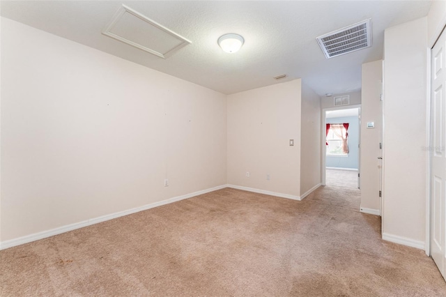 unfurnished room featuring light colored carpet and a textured ceiling