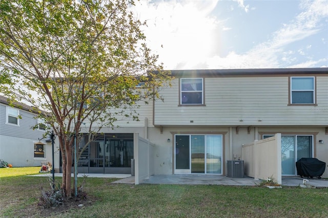 back of property featuring central AC unit, a sunroom, a patio area, and a yard