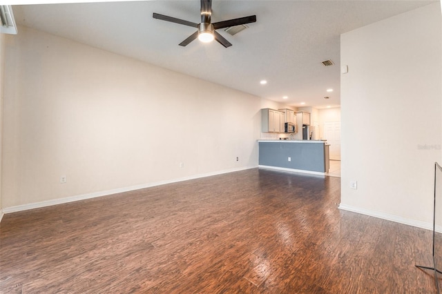 unfurnished living room with dark hardwood / wood-style flooring and ceiling fan