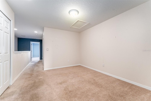 carpeted empty room with a textured ceiling